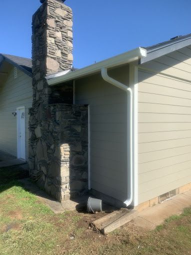 A house with a chimney and a gutter on the side of it.