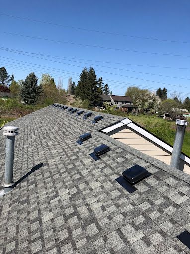 A roof with a lot of vents on it and a blue sky in the background.