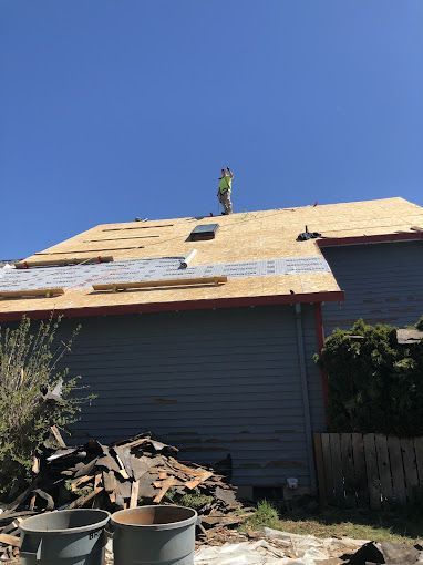 A man is standing on the roof of a house.