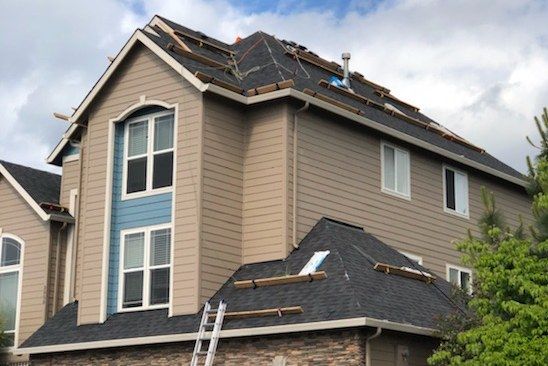A large house with a ladder on the side of it.