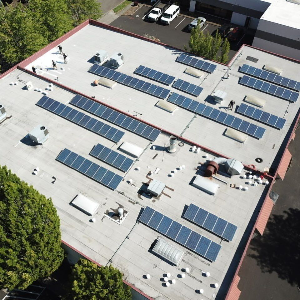 An aerial view of a building with solar panels on the roof.