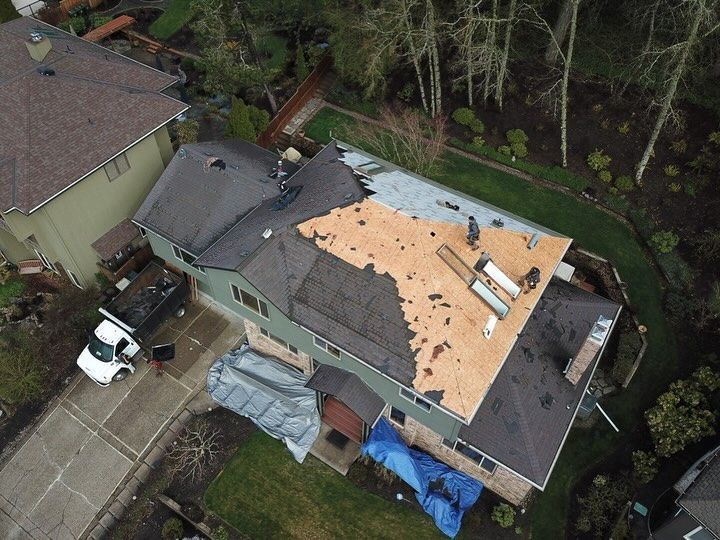 An aerial view of a house with a roof that is being repaired.