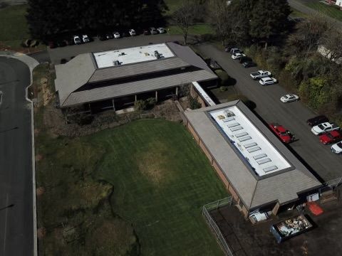An aerial view of a building with a lot of cars parked in front of it.