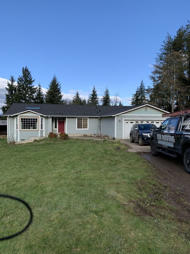 A couple of cars are parked in front of a house.