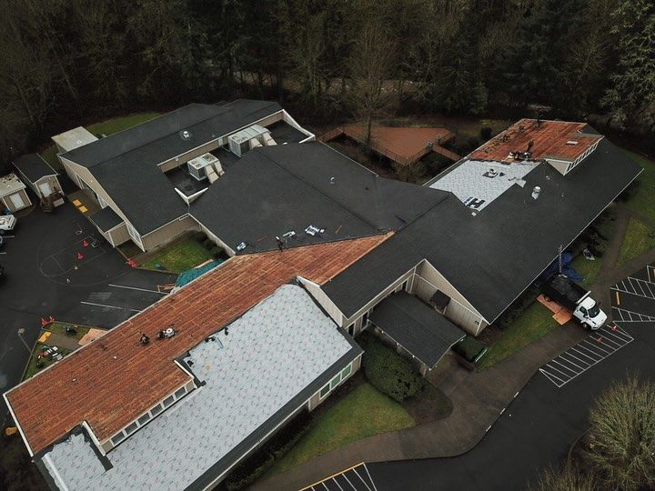 An aerial view of a large building with a roof that is being repaired.