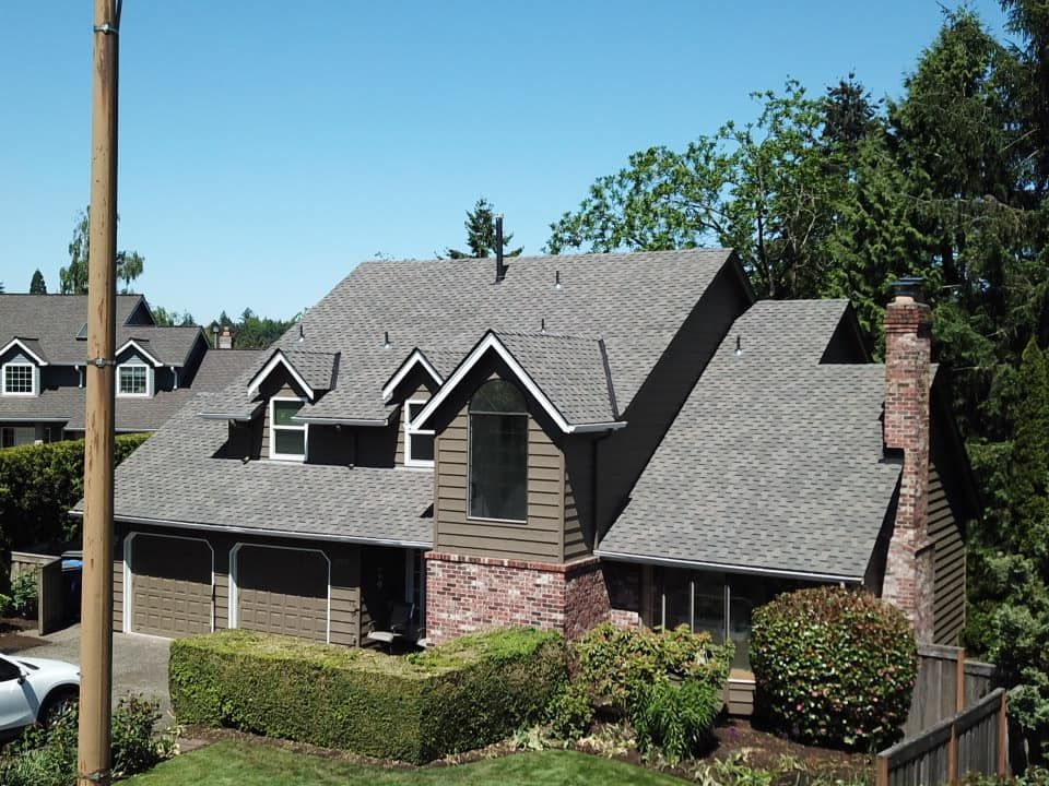 A house with a gray roof is surrounded by trees.