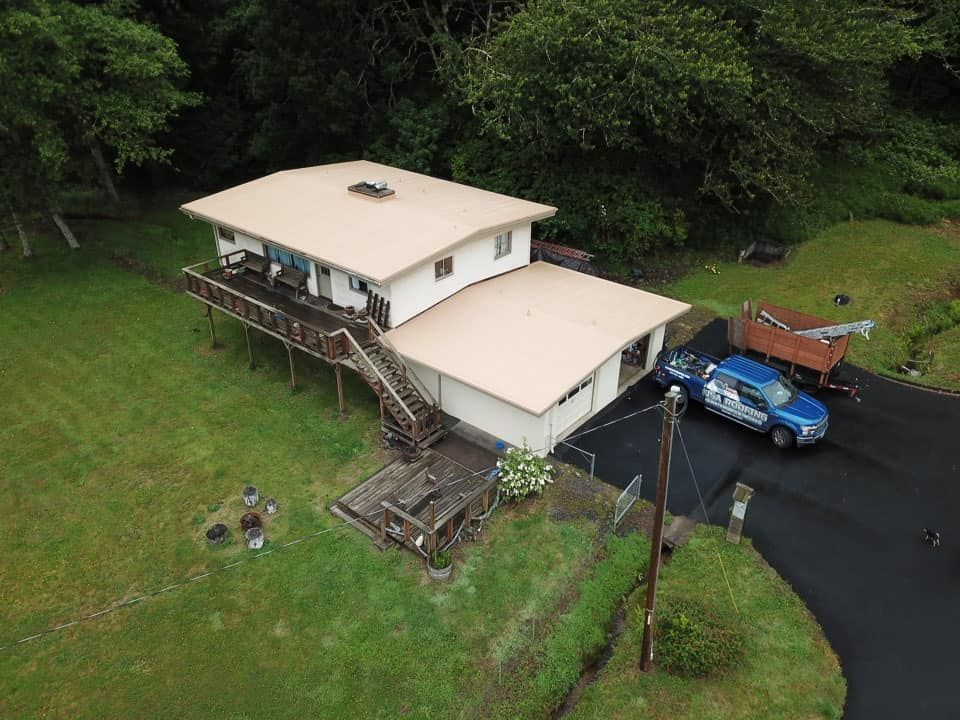 An aerial view of a house with a blue truck parked in front of it.