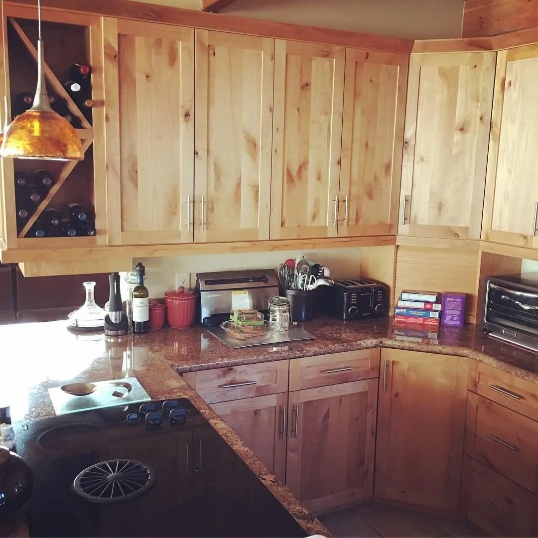 Wooden kitchen corner with pine cabinets, granite countertops, and small appliances on the counter