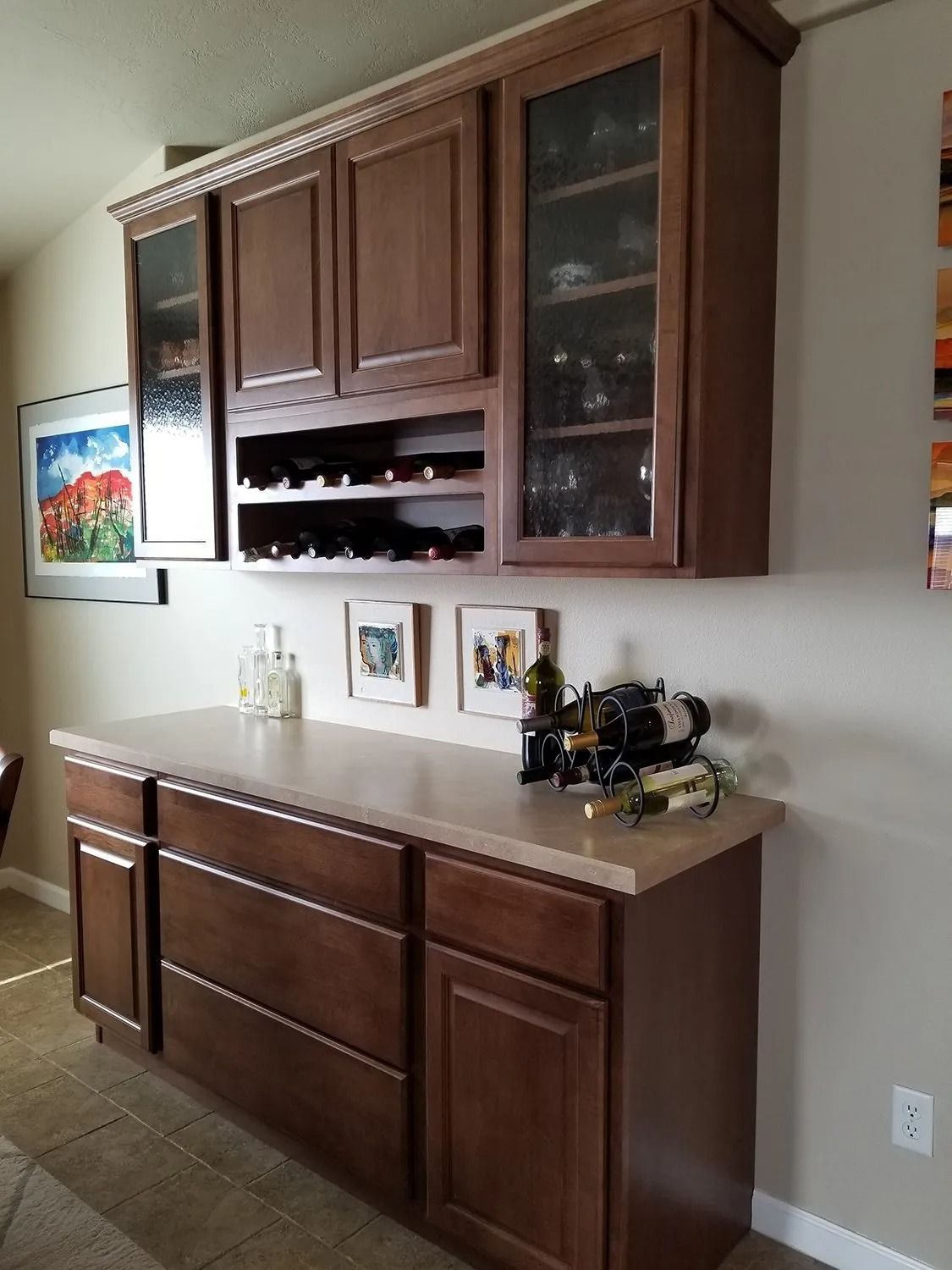Dark wooden wall cabinet and sideboard in a dining room with framed photos and small decor items.