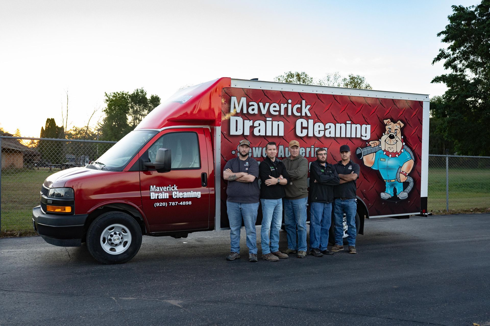 Maverick Drain Cleaning truck with five workers standing beside it in a parking lot