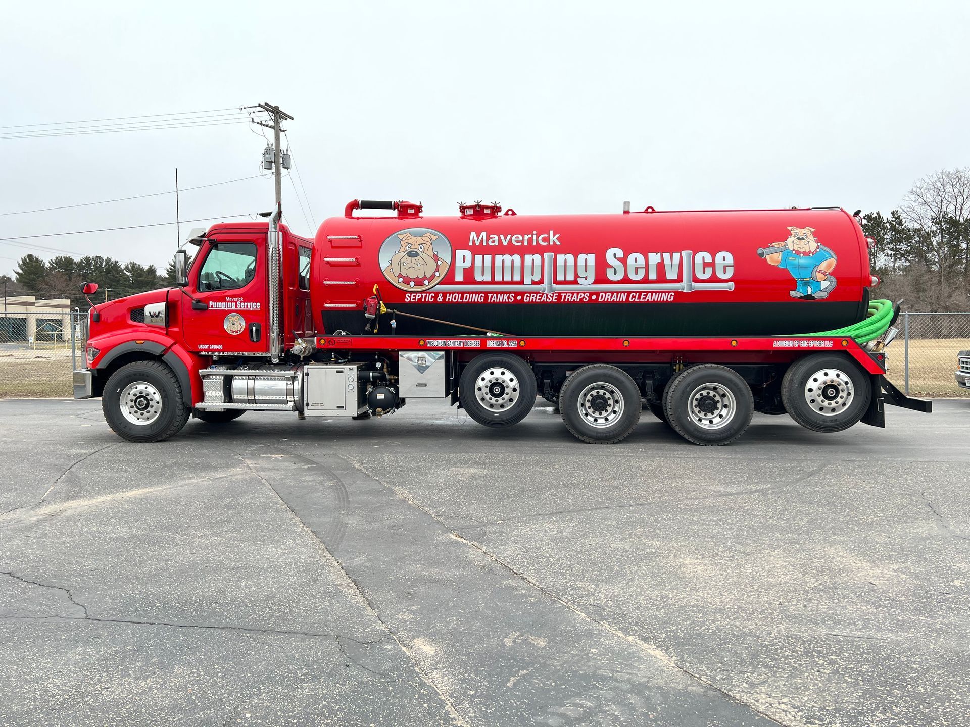 Red vacuum pumping service tanker truck parked on a lot