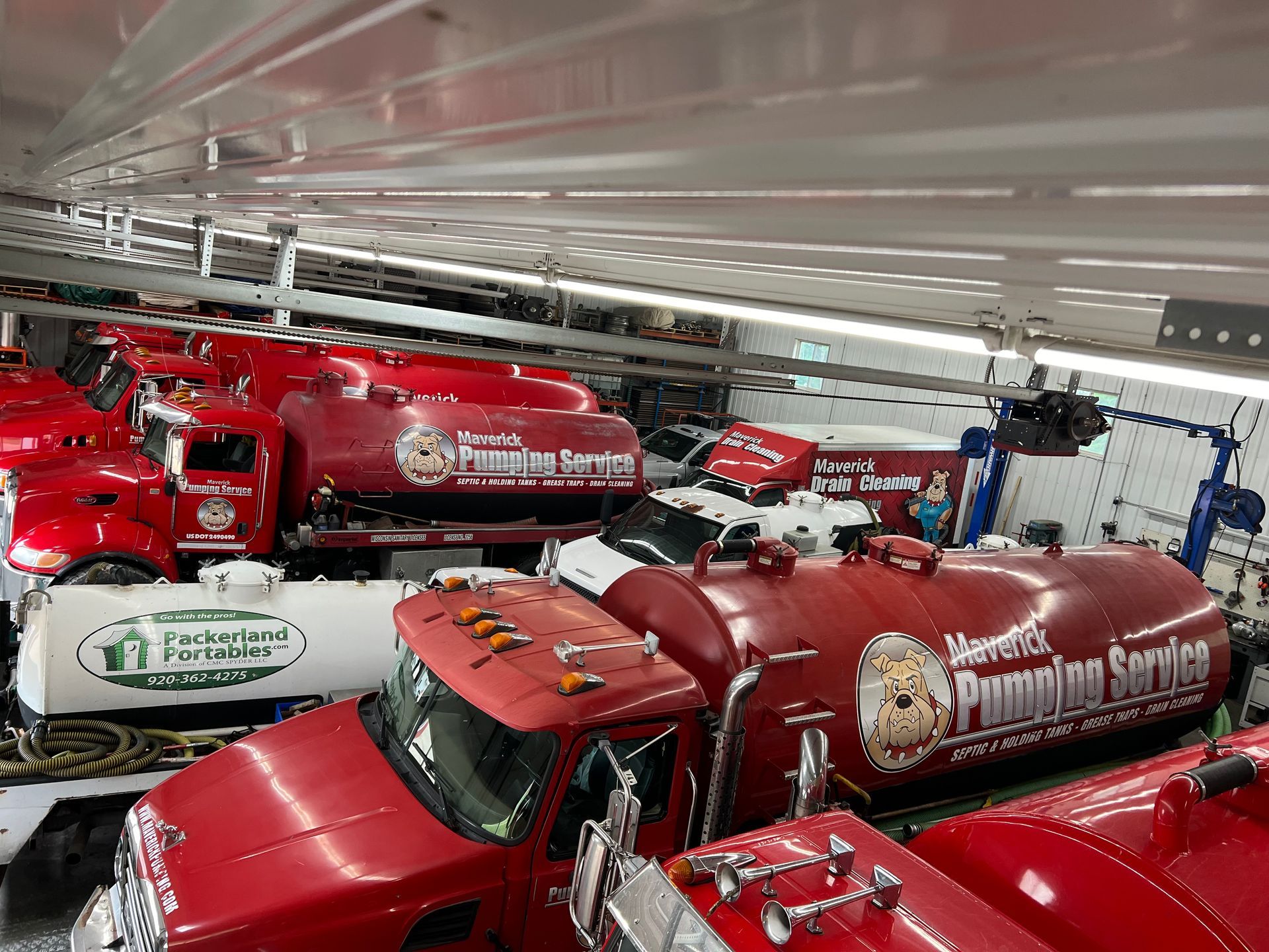 Red fire trucks parked closely together in a garage, viewed from above.