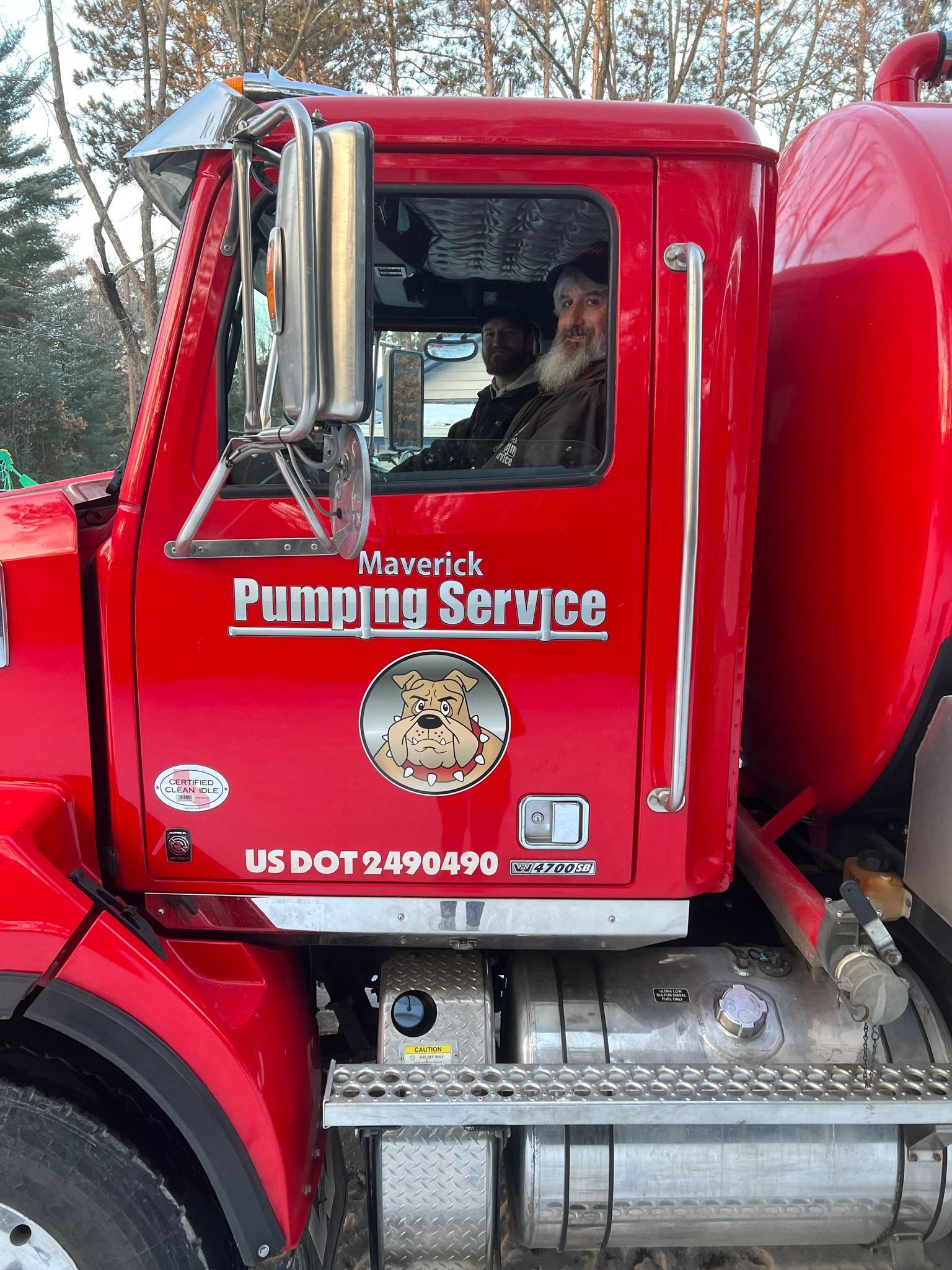Red Maverick Pumping Service truck with driver visible in the cab.
