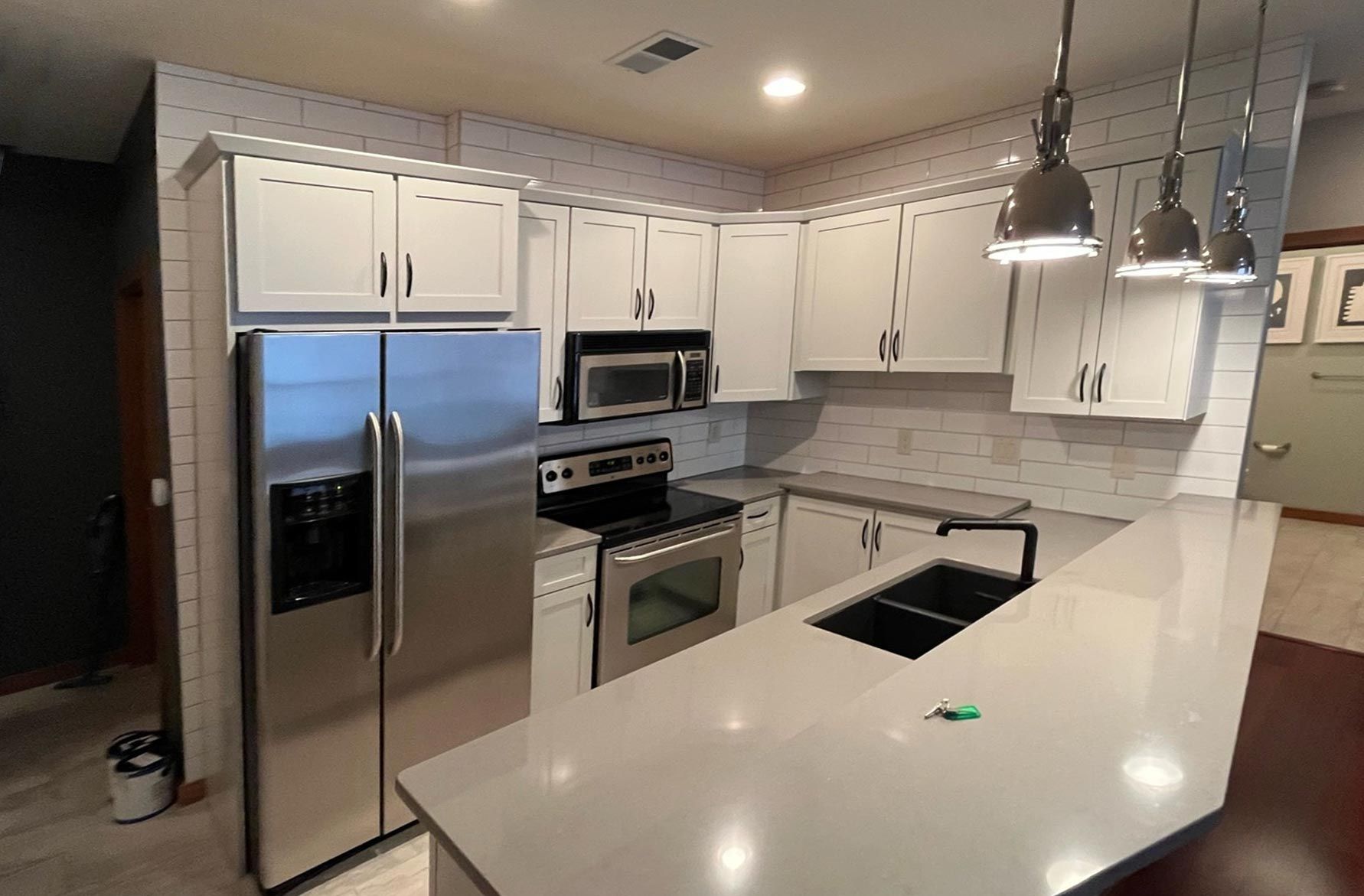 A kitchen with white cabinets and stainless steel appliances.