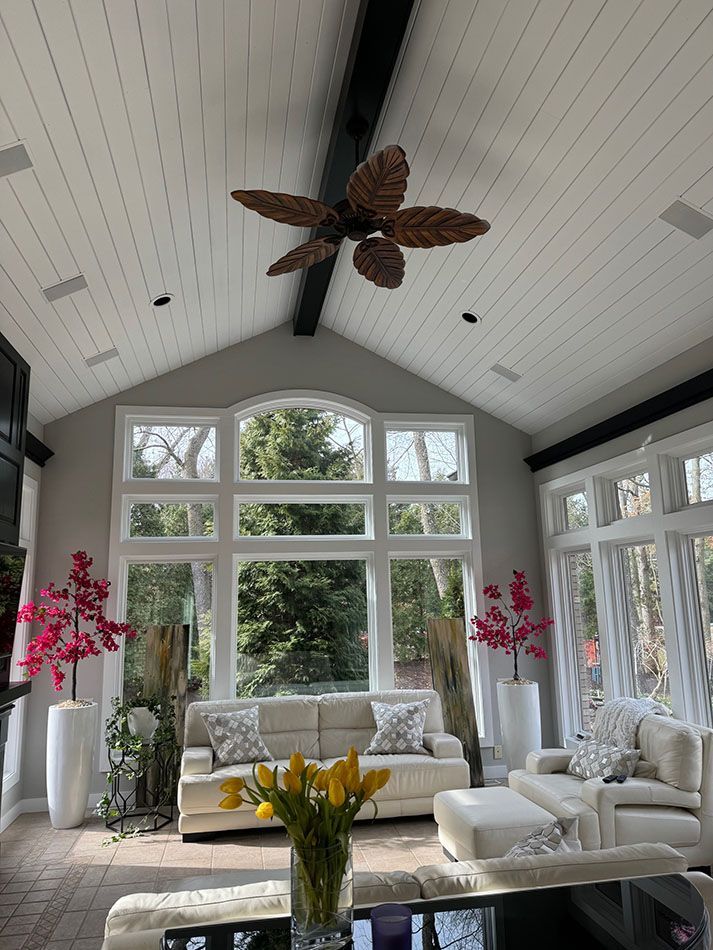 A living room with a vaulted ceiling and a ceiling fan.