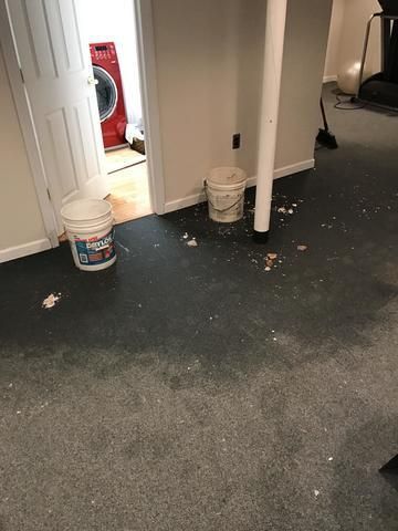 two buckets are sitting on the floor of a basement