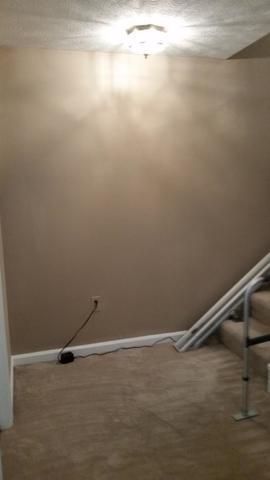 an empty room with a staircase and a wall