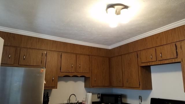 a kitchen with wooden cabinets and a ceiling light
