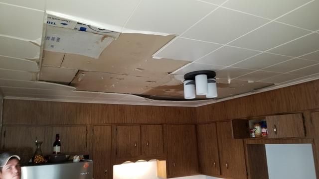 a kitchen with a ceiling that has a hole in it