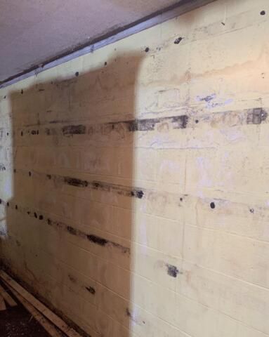 a brick wall with a lot of holes in it and a shadow on it