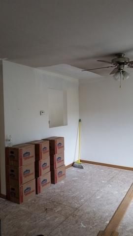 a room with boxes stacked on top of each other and a ceiling fan