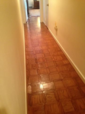 a long hallway with a wooden floor and white walls