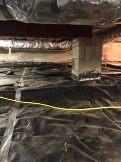a basement with a lot of plastic covering it and a yellow cord
