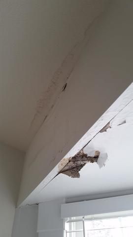 a ceiling with a hole in it in a room with a window