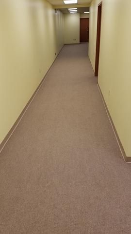 a long hallway with a carpeted floor and yellow walls