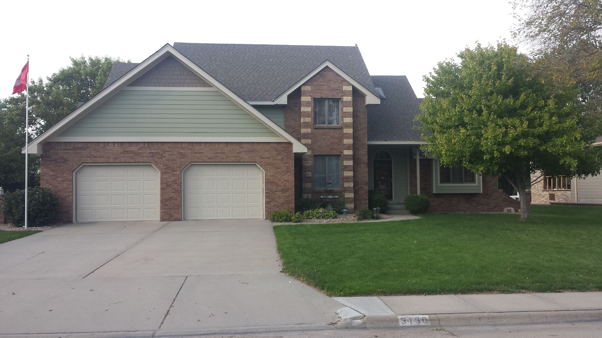 A large brick house with two white garage doors