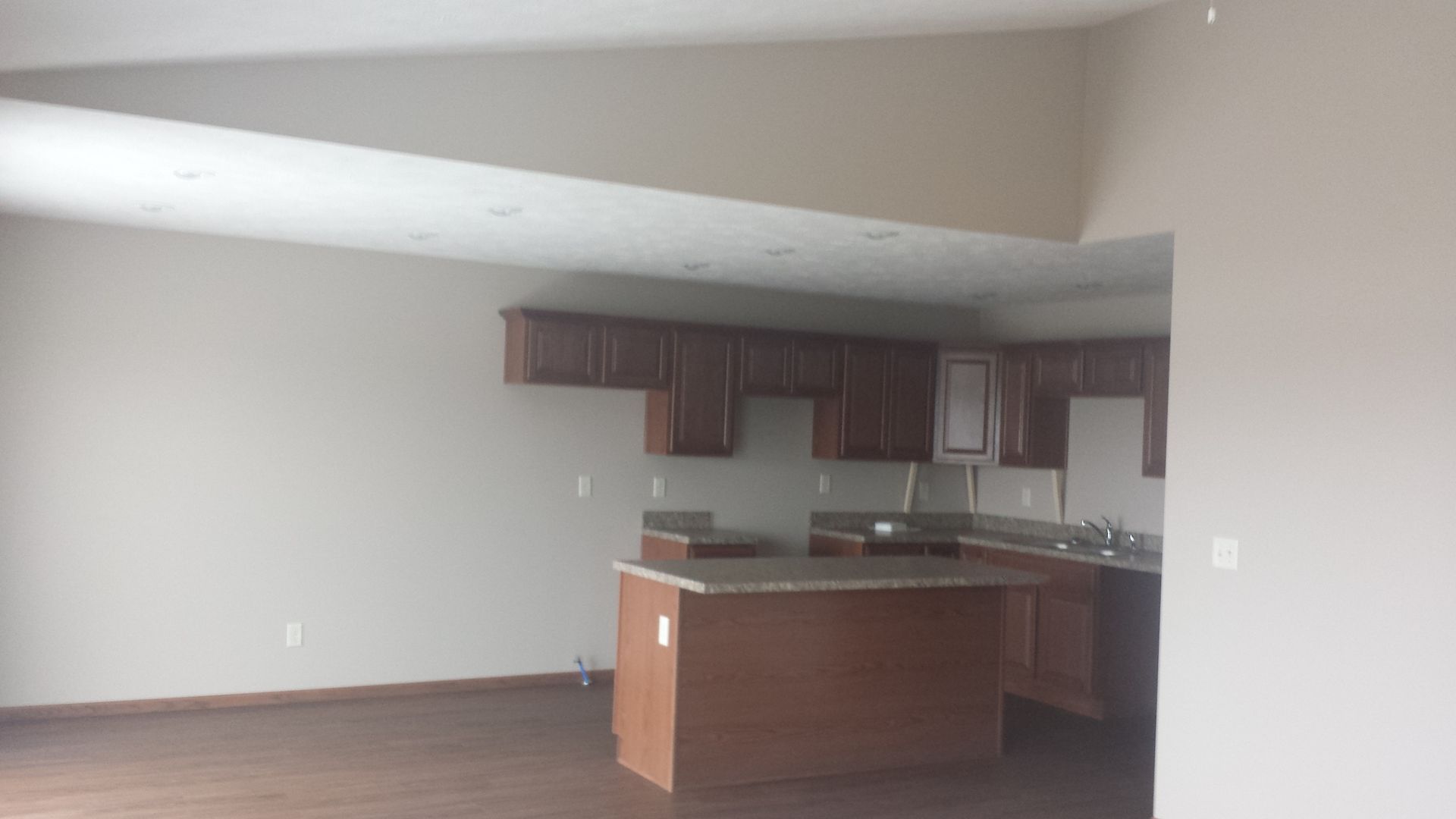 An empty kitchen with a large island in the middle