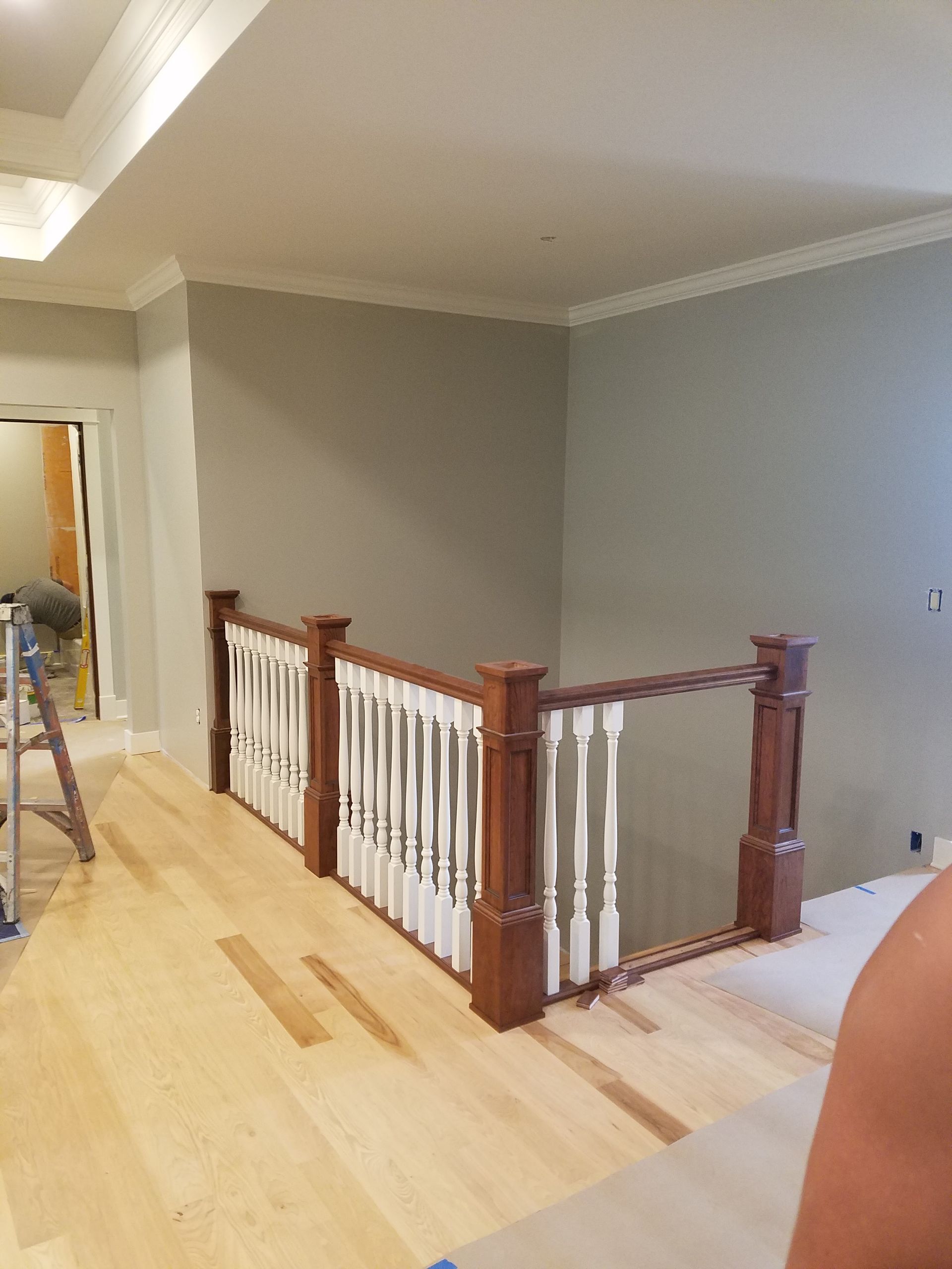 A wooden staircase with a white railing in a room.