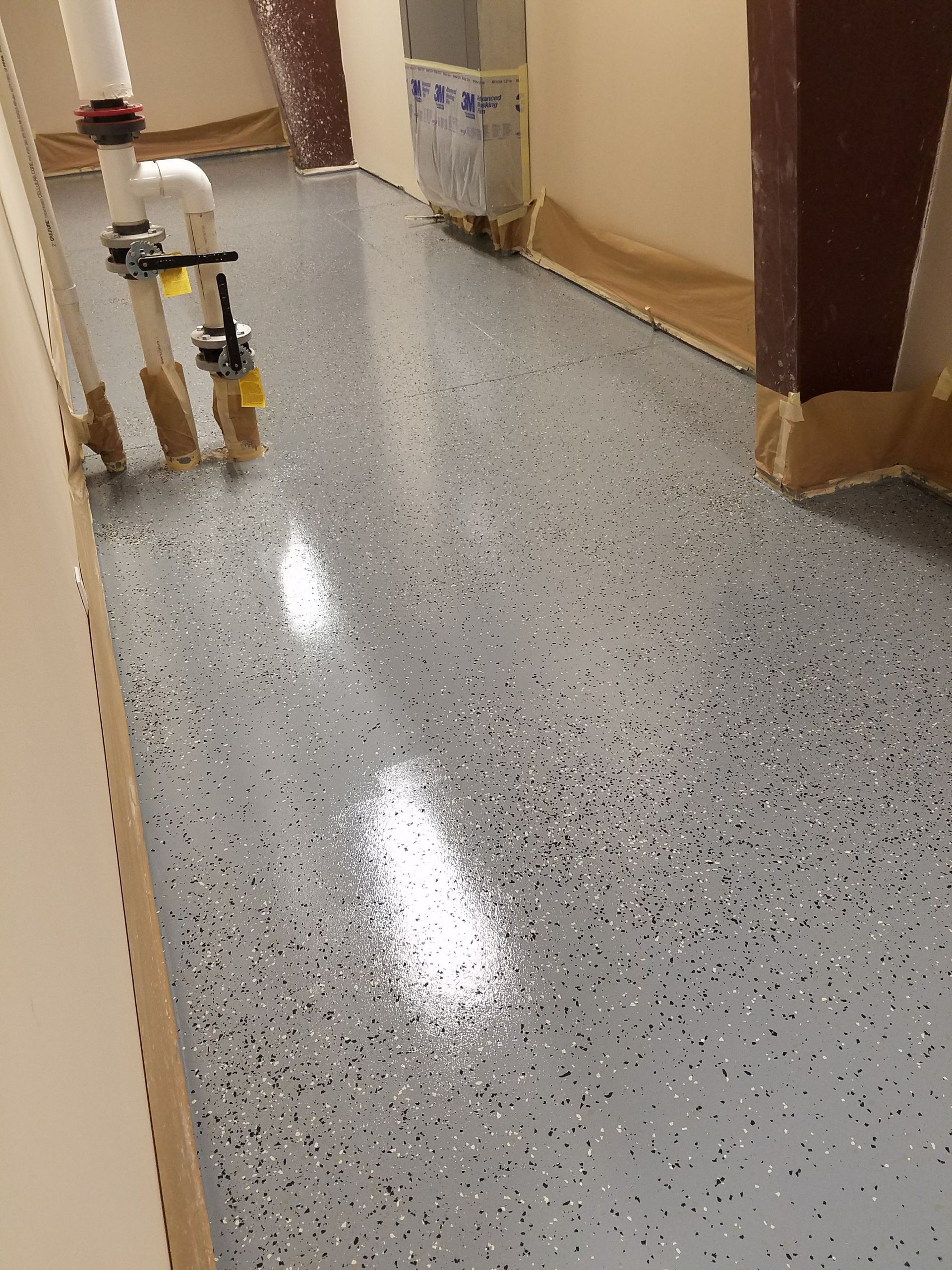 A gray floor with a lot of small dots on it