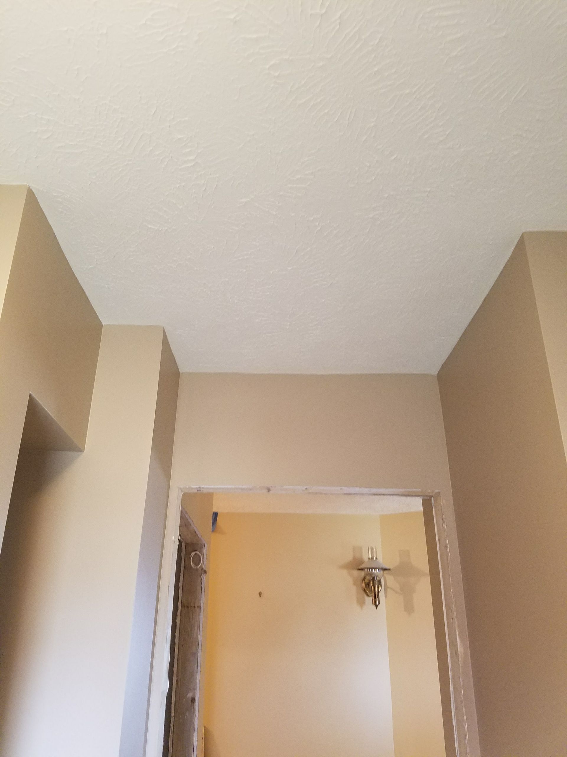 A hallway with a light on the ceiling and a ceiling fan.