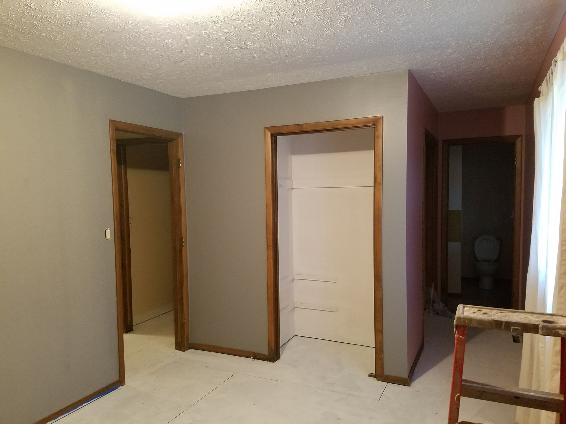 An empty room with a ladder in the middle of it.