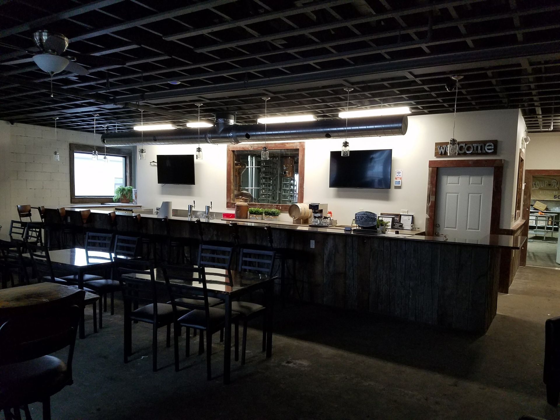 A large room with tables and chairs and a bar