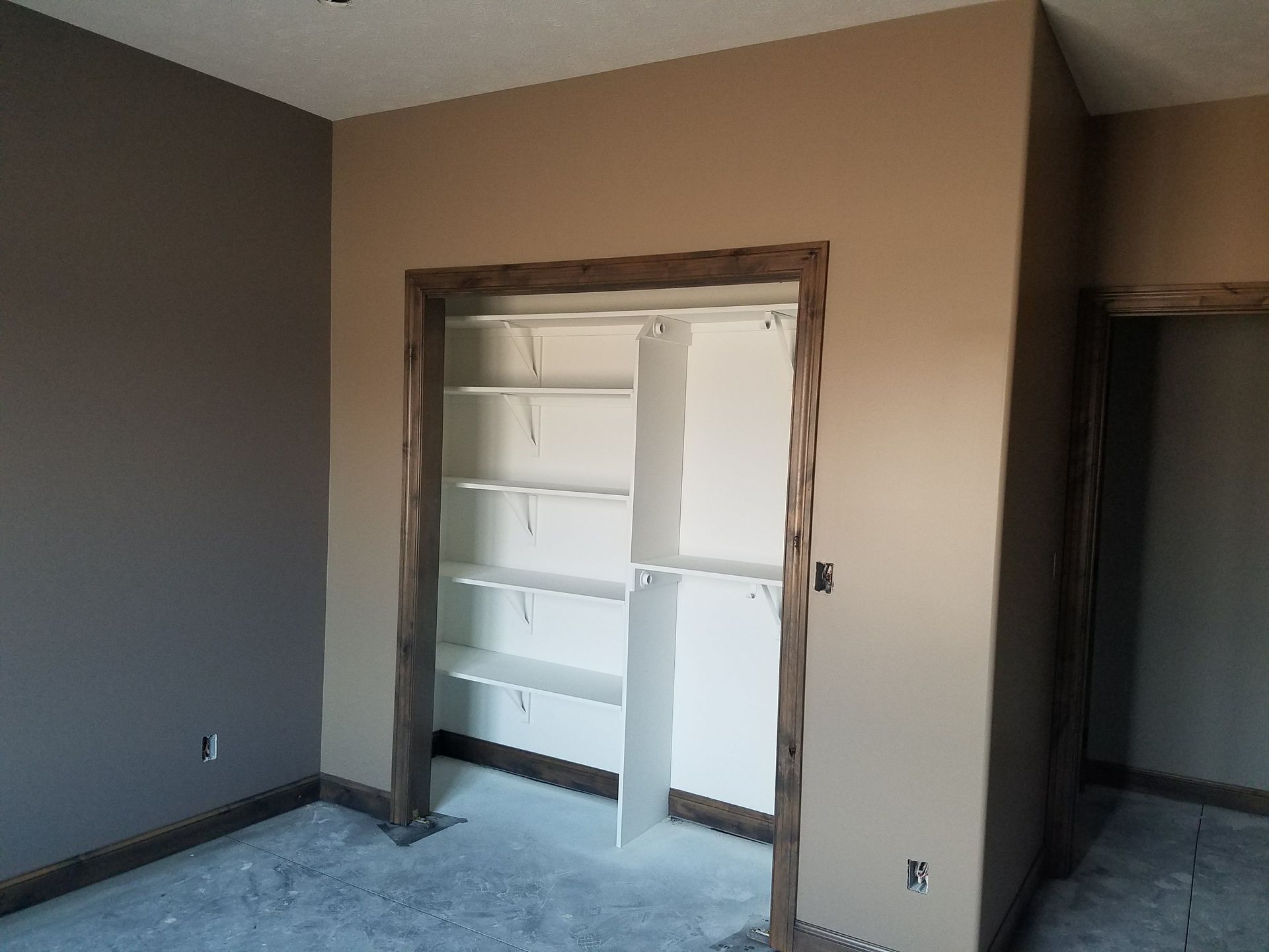 An empty room with a closet and shelves in it.
