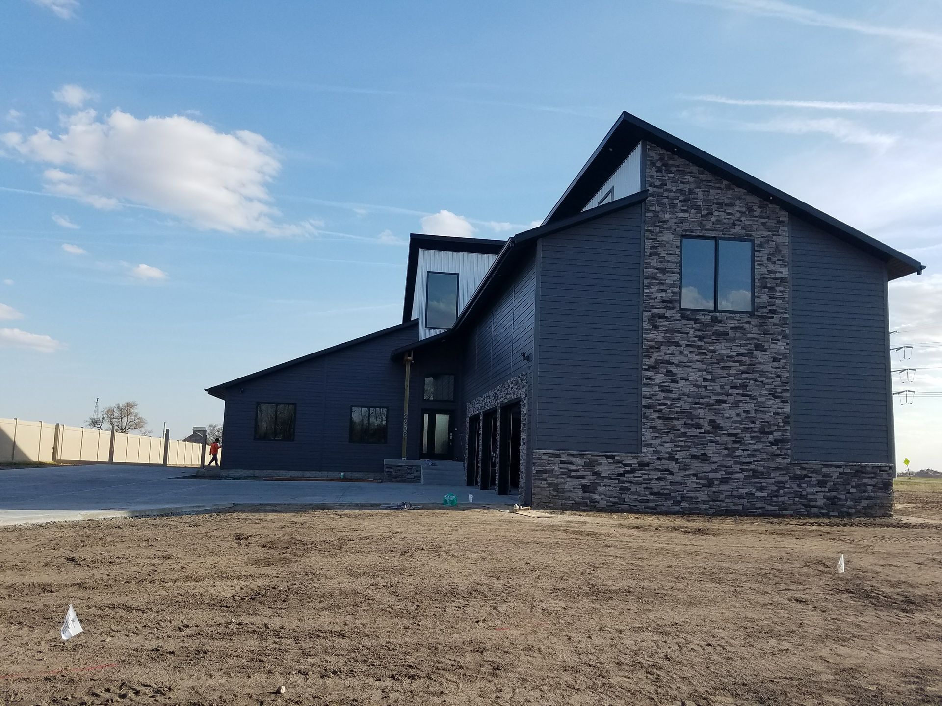 A large house with a lot of windows is sitting in the middle of a field.