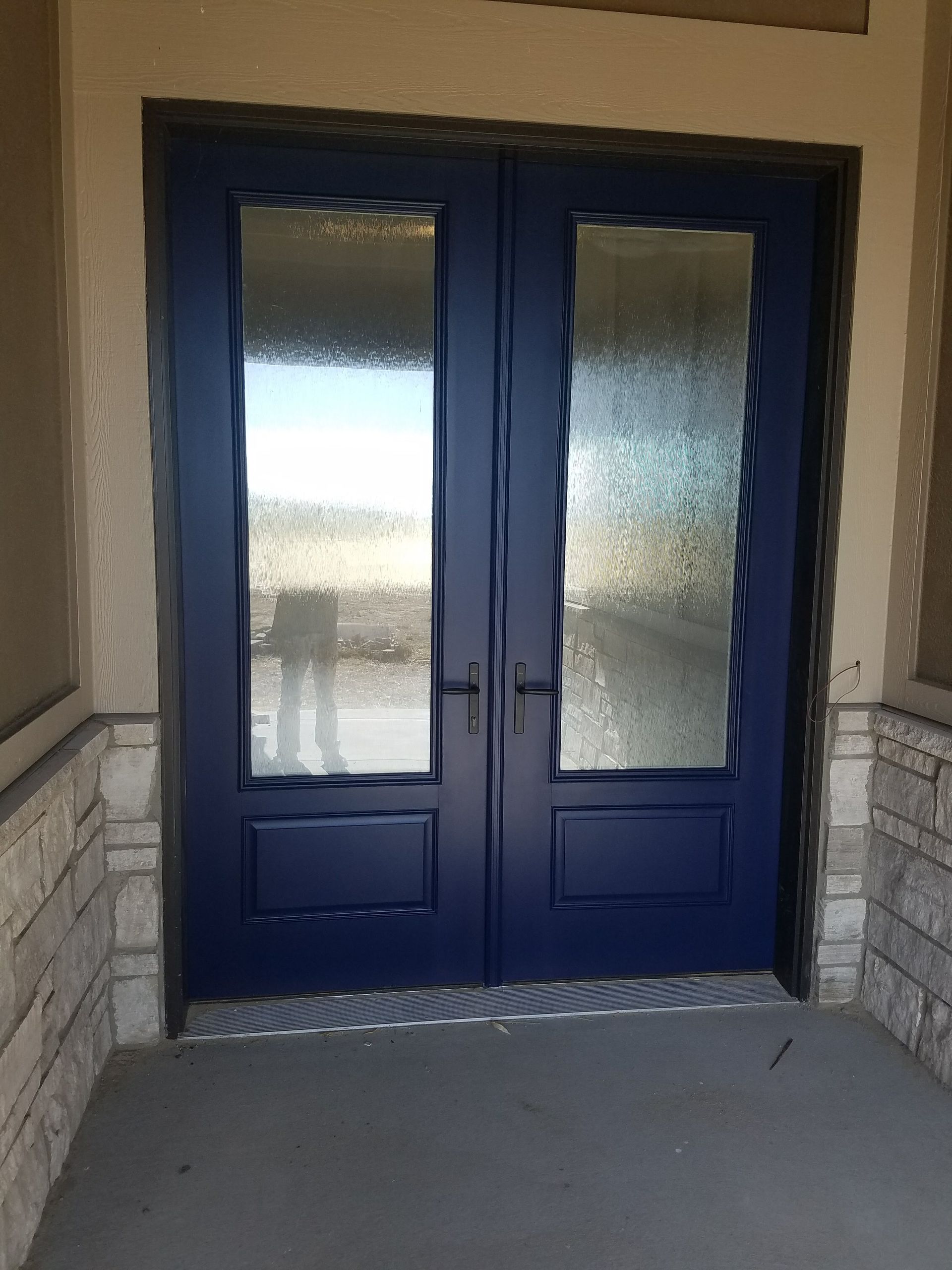 A blue door with a lot of glass on it