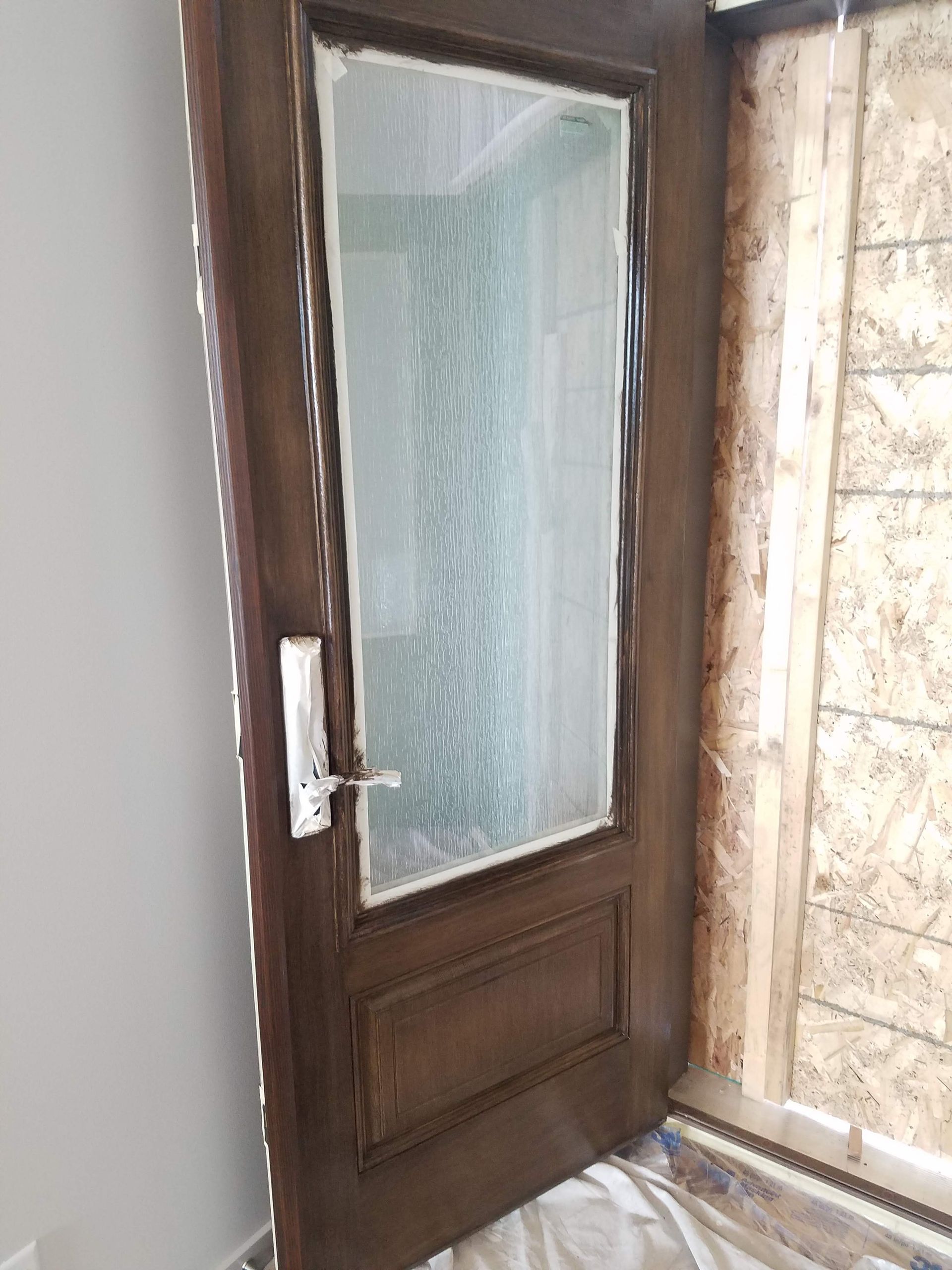 A wooden door with a glass window in a room.