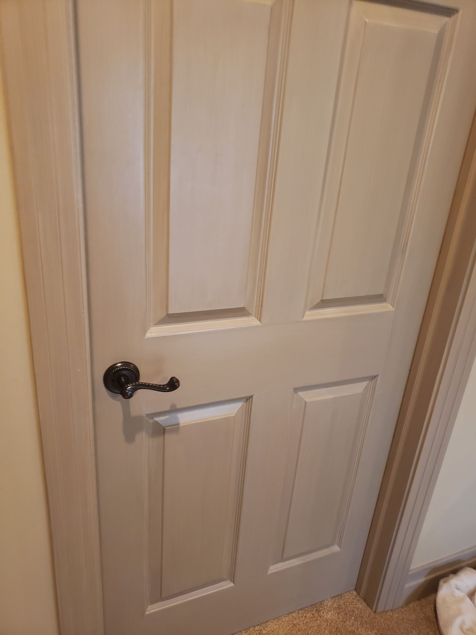 A white door with a black handle is in a room.