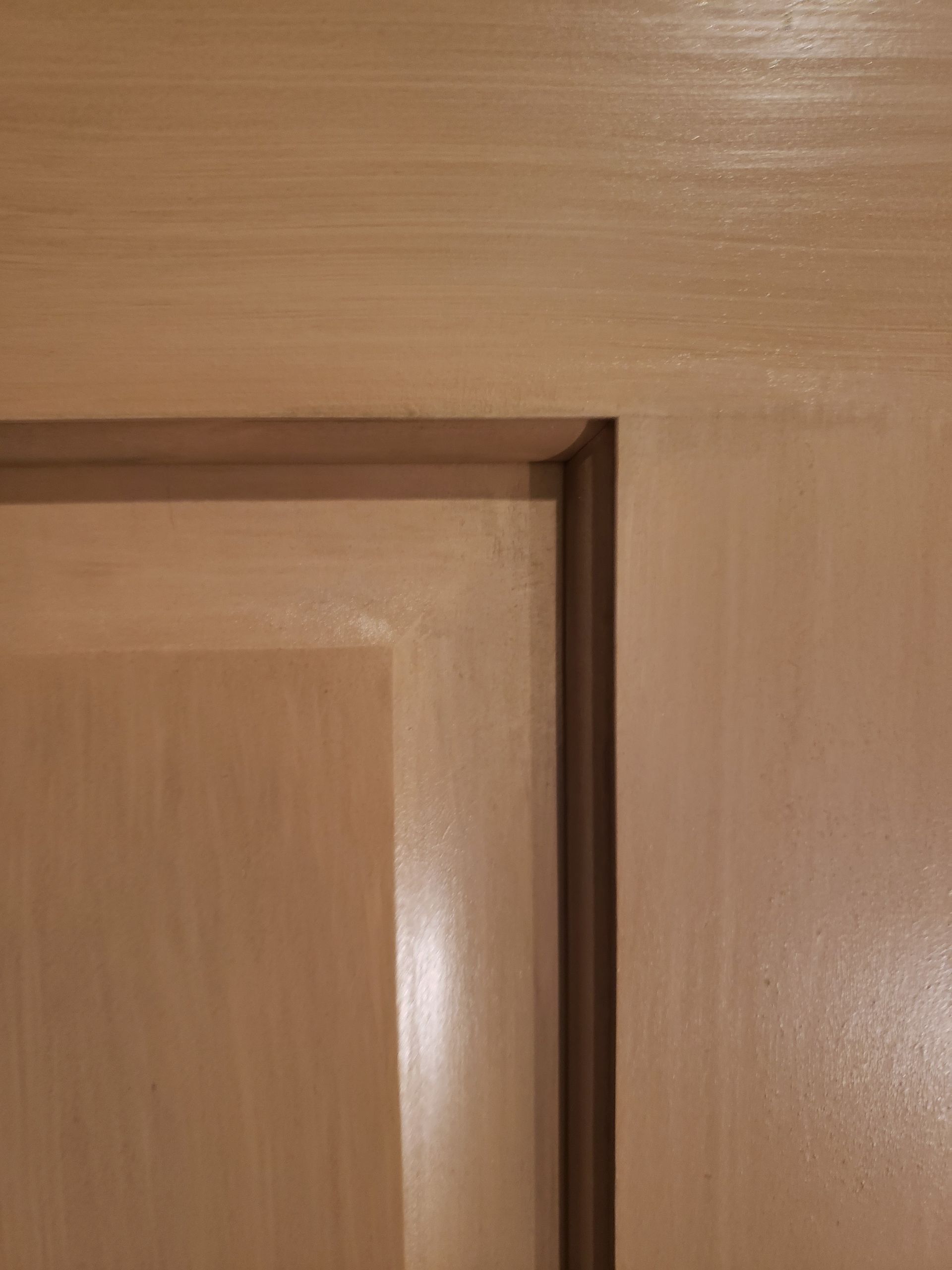 A close up of a wooden door with a corner.