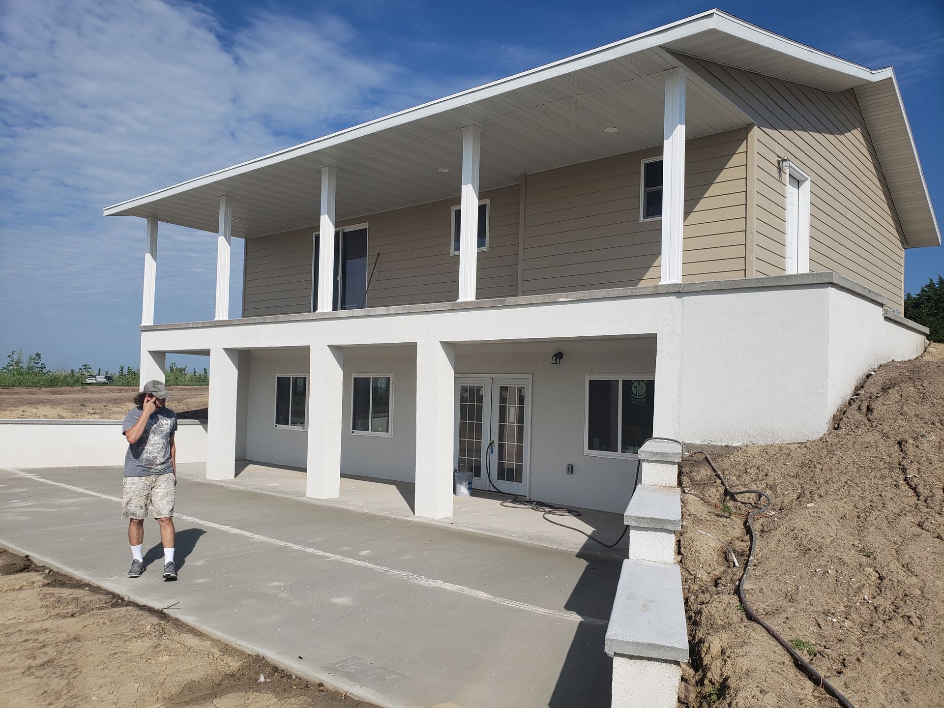 A man is standing in front of a large house