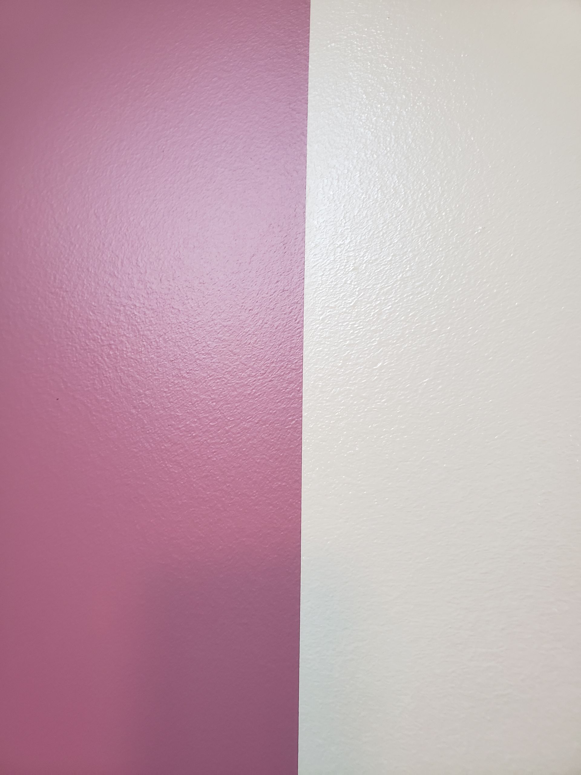 A close up of a pink and white wall.