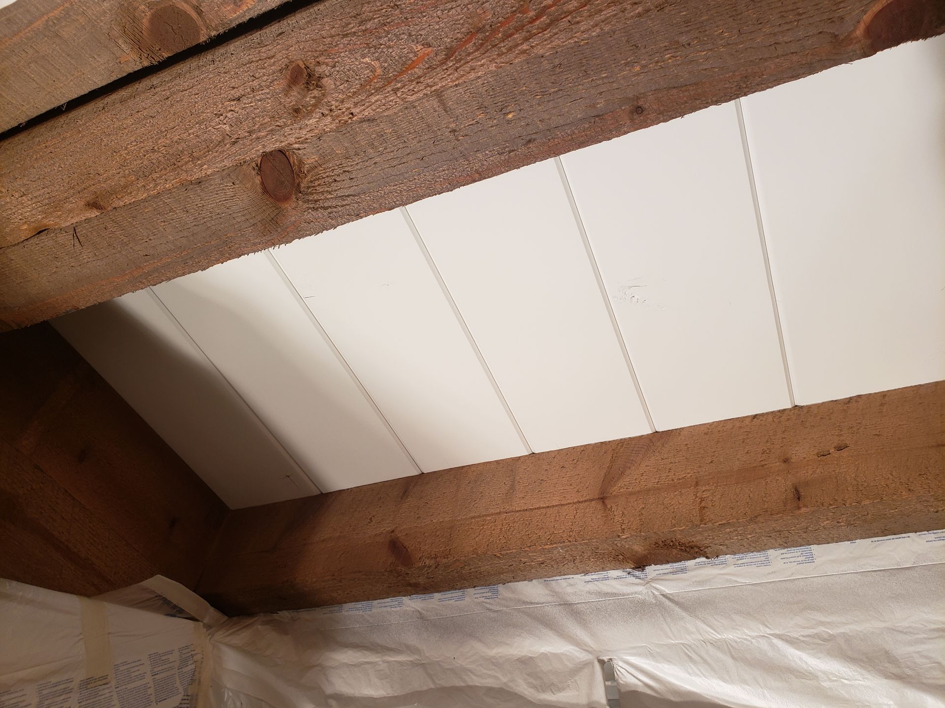 A wooden ceiling with white paneling on it