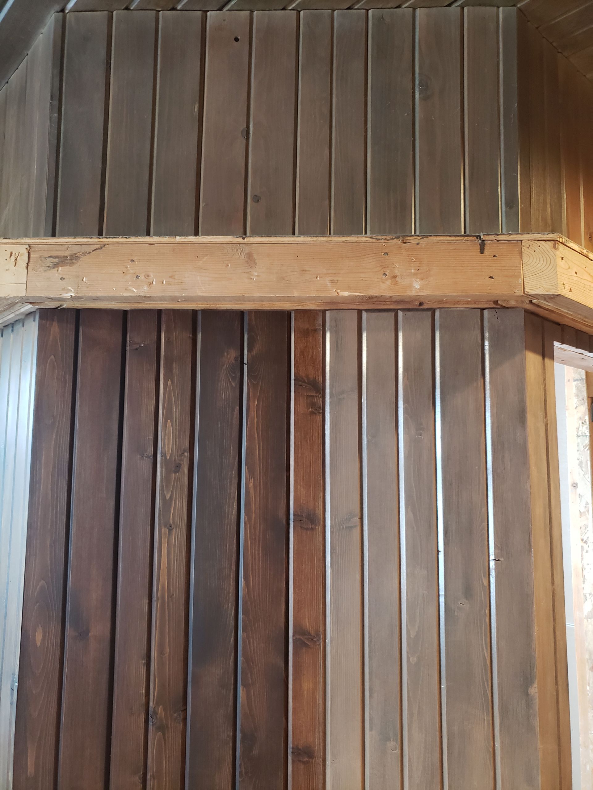 A wooden wall with a wooden beam hanging from it.
