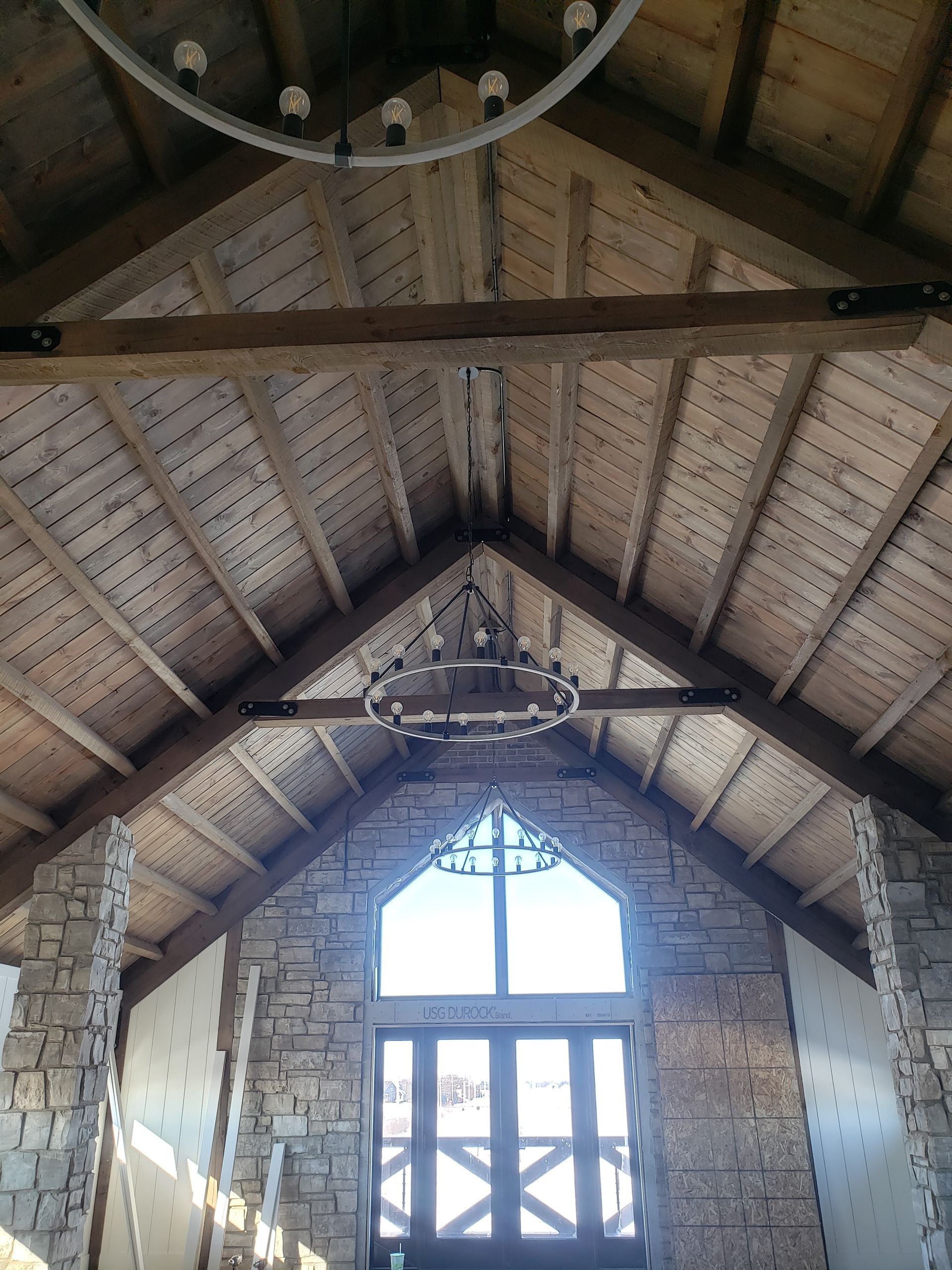 A wooden ceiling with a chandelier hanging from it