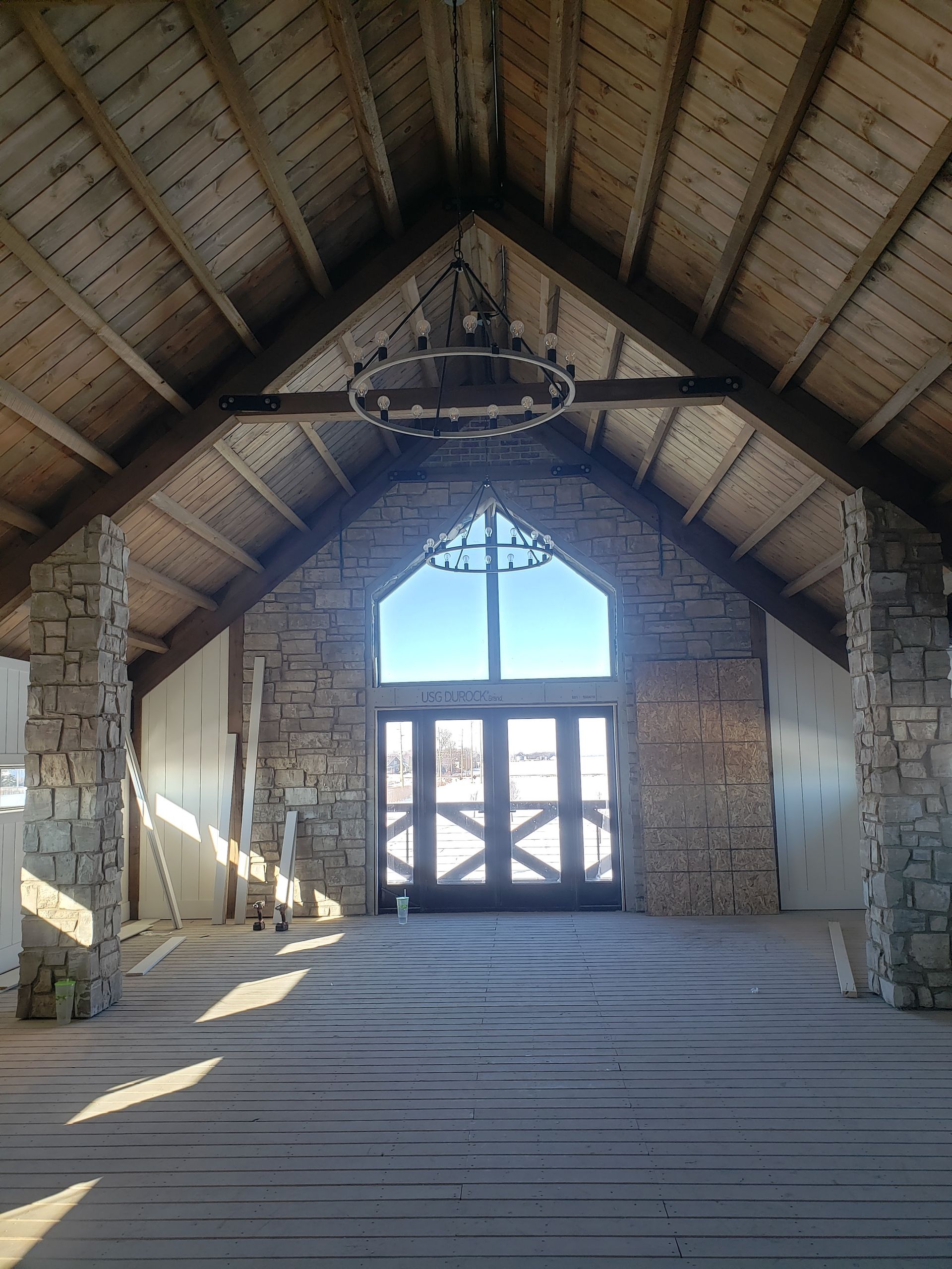 An empty room with a wooden ceiling and a large window