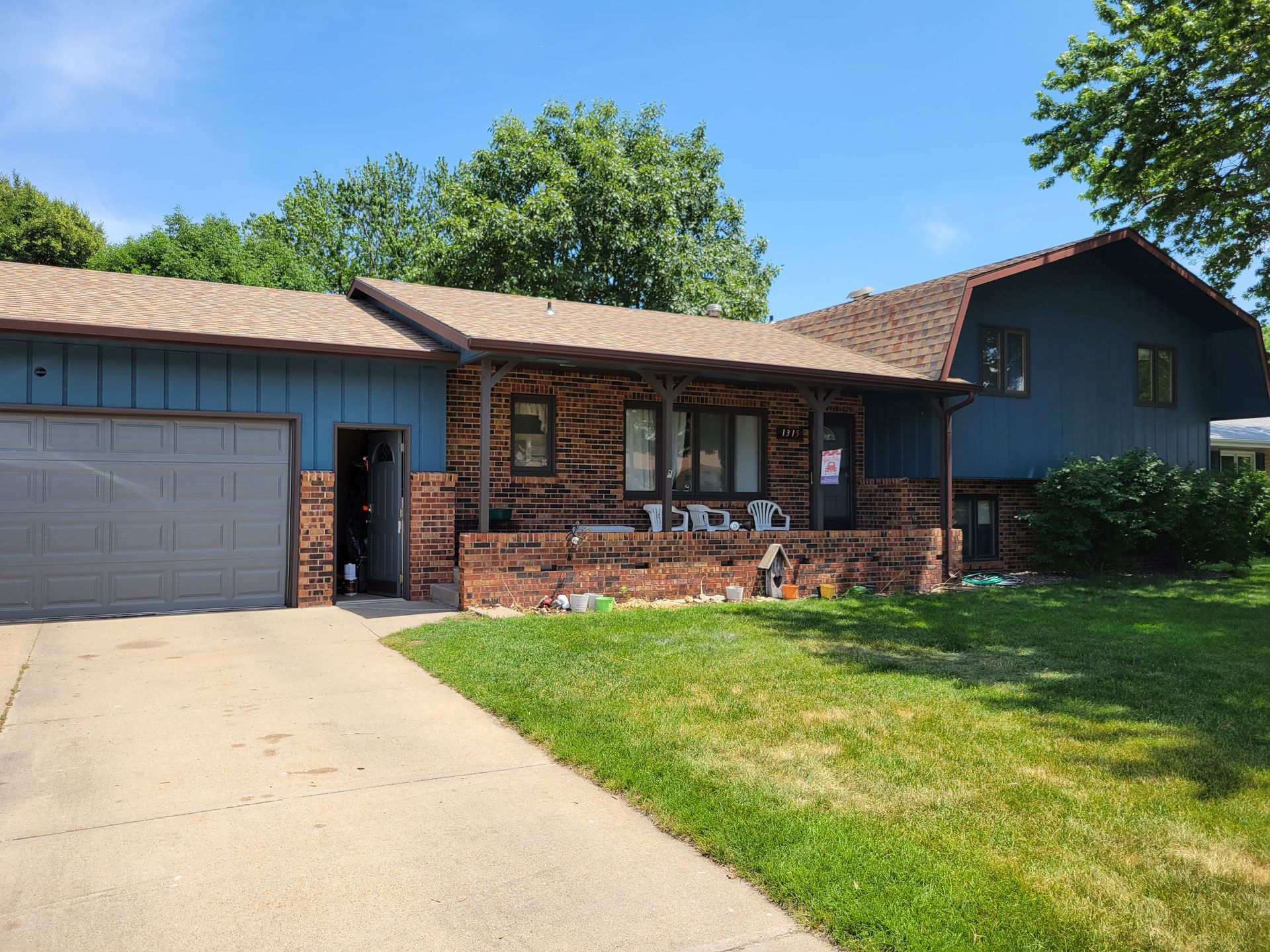 A blue house with a garage and a porch