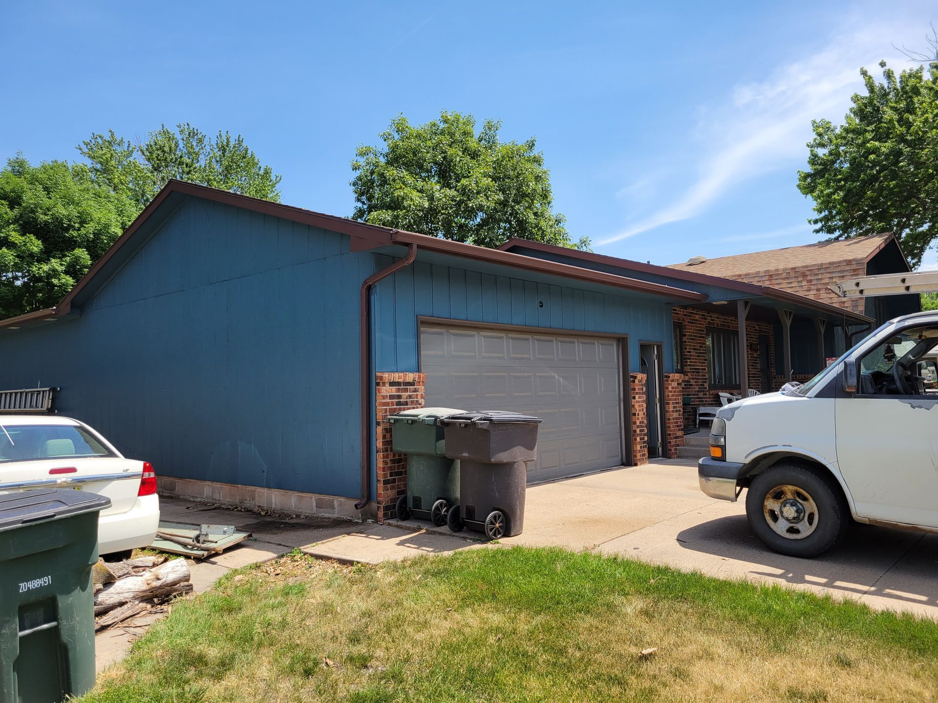 A blue garage with a white van parked in front of it.